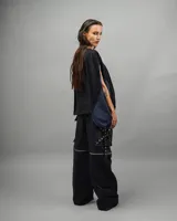 Remera negra con diseño asimétrico y detalles en azul. Corte holgado y mangas cortas.