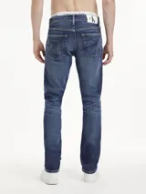 Pantalón de jean azul oscuro, de corte slim y talle alto, con diseño de cinco bolsillos y cierre con cremallera y botón.