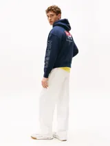 Buzo azul marino amplio con capucha y cordón distintivo, bolsillo canguro, puños y bajo de punto canalé, logo oversize de Tommy Hilfiger en la manga y la parte trasera, parche con logo de Tommy Hilfiger en el pecho y detalles distintivos de Hilfiger Sailing.