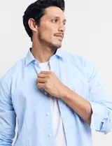 Camisa celeste de manga larga con cuello button-down, confeccionada en tejido rústico de algodón y lino.