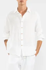 Camisa blanca de manga larga confeccionada en lino 100%, con calce recto y relajado. Presenta frente abotonado con botones de coco con logo y parche con logo de la marca.