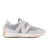 Championes New Balance modelo 327 para mujer, color gris claro y gris medio, con logo 'N' superpuesto en gamuza. Presentan una entresuela blanca y suela exterior de goma color caramelo con tacos prominentes.