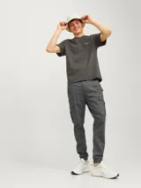 Pantalón cargo gris oscuro, corte slim fit, con puños elastizados, tiro medio, cierre con cremallera y múltiples bolsillos.