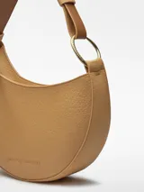 Bolso de hombro tipo baguette color crema, con textura granulada y asa corta regulable.