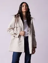 Gabardina impermeable color beige, marca Weatherproof, con abertura central con botones, bolsillos delanteros y capucha desmontable.