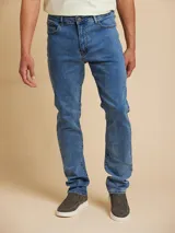 Jean de corte ajustado en denim azul claro, con cinco bolsillos y cierre frontal.