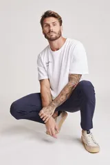 Pantalón de vestir azul marino, de corte recto, con bolsillos laterales y traseros. Se ajusta a la cintura con cinturón de cuero marrón.