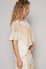 Remera corta color beige con diseño patchwork, escote redondo con botones y mangas cortas.