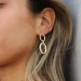 Caravanas doradas con diseño minimalista de eslabones entrelazados.