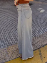 Pantalón de jean celeste de tiro medio con pierna extra ancha y caída fluida, con bolsillos delanteros y traseros, y cierre frontal con cremallera y botón metálico.