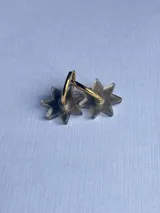 Par de aros colgantes con forma de estrella transparente y aro dorado.