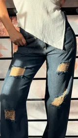 Pantalón de jean azul oscuro de corte recto, con roturas y bolsillos delanteros.