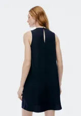 Vestido corto sin mangas color beige, de corte recto y cuello redondo.