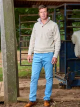 Sweater verde oscuro de lana lambswool, con cuello alto abotonado y logo bordado en el pecho.