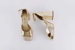 Sandalias de cuero color dorado con plataforma, tacón cuadrado y pulsera al tobillo.