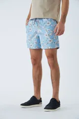 Short de baño azul con estampado de hojas y flores en blanco. Tiene cintura elástica con cordón ajustable, dos bolsillos laterales y uno trasero.
