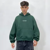 Buzo hoodie verde oscuro con corte boxy y logo estampado en el pecho.