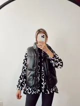 Sobrecamisa de plush con estampado animal print en blanco y negro, con cuello camisero, cierre frontal con botones, mangas largas abullonadas y bolsillos laterales.