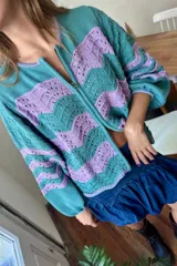 Campera de tejido de punto con cierre frontal doble, presentando un patrón de ondas en colores azul marino y crudo.