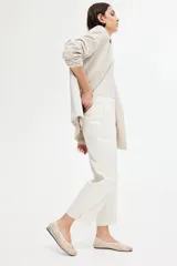 Pantalón cigarette tobillero color blanco, con cintura estándar, cierre y pretina prolongada con corchete oculto. Piernas ajustadas con abertura corta en los bajos, bolsillos al bies y bolsillo de atrás decorativo. Pliegues adelante y atrás.