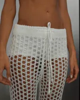 Pantalón de red calado color blanco, estilo playero, con cordón ajustable en la cintura.