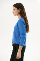 Sweater azul de tejido de punto con cuello redondo y mangas largas.