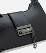 Cartera baguette pequeña de PU negro con acabado brillante, asa corta fija, cierre superior con cremallera y detalles metálicos. Incluye una cadena metálica decorativa en el frente.