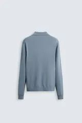 Polo celeste de punto con mezcla de algodón, seda y lino. Corte relaxed fit, cuello solapa con abertura frontal, manga larga y acabados en rib.