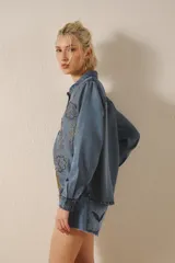 Camisa de tencel celeste con bordado de lentejuelas doradas, calce recto, manga larga y cuello camisero.