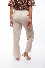 Pantalón de viscosa y lino color beige, de corte recto, con cintura elástica y cordón ajustable.