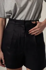 Short negro de tiro alto con pliegues y textura, de corte holgado.