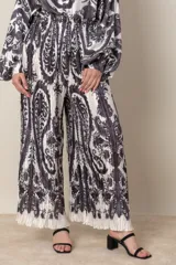 Pantalón palazzo plisado con estampado abstracto en blanco y negro, cintura elastizada y corte amplio.