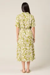 Vestido midi con estampado de hojas en verde y blanco, cuello camisero, botones frontales, manga corta y cinturón.