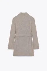 Blazer marrón claro con estampado a cuadros, cuello solapa, manga larga con hombreras, bolsillos delanteros y cierre cruzado con cinturón del mismo tejido.