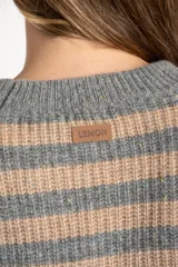 Sweater de tejido de punto con diseño de rayas horizontales alternando gris y beige. Presenta cuello redondo y mangas largas con costura decorativa visible en los laterales.