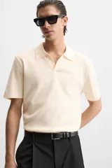 Polo color crema de punto, corte regular fit, cuello solapa con abertura frontal y manga corta.