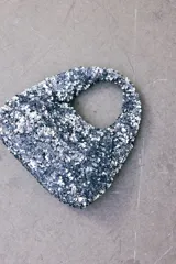 Cartera de mano plateada cubierta de lentejuelas, con asa corta y forro interior.