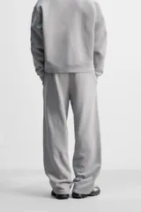 Pantalón jogger gris de corte recto, confeccionado en tejido de algodón compacto con interior en rizo. Cuenta con cintura elástica ajustable con cordón interior, bolsillos frontales y bolsillo de doble vivo en la espalda.