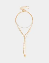 Set de tres collares dorados de diferentes largos. Uno con perlas sintéticas, otro con cruces de metal y el tercero con dije de corazón con alas.