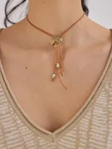 Collar con cordón regulable y dije dorado con textura irregular, inspirado en medusas.