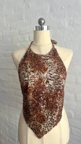 Top con estampado abstracto en tonos marrones y blancos, con tiras para atar en el cuello y la espalda.