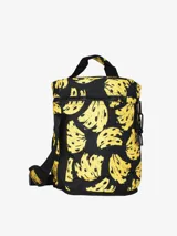 Bolso térmico cilíndrico con estampado de bananas amarillas sobre fondo negro. Tiene cierre superior, asa de mano y correa de hombro ajustable con logo de la marca.