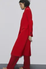 Abrigo rojo de lana con doble botonadura, cuello con solapa y bolsillos con solapa en la parte delantera.