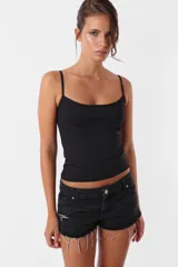 Short de jean negro con roturas, tiro medio, cintura con pasacintos, cierre y botón metálico.
