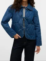 Campera de denim azul con cuello tipo spread collar, bolsillos delanteros, forro completo y acolchado ligero. Confeccionada en tejido sastrero twill con 80% algodón y 20% poliéster, presenta un acabado enzyme wash para una textura más suave y un efecto stonewash que aporta un look desgastado y vintage.