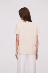 Remera holgada de algodón color blanco, con manga corta y cuello redondo.