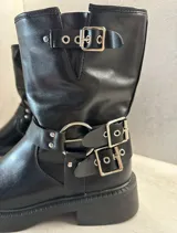 Botas cortas de cuero sintético negro con hebillas plateadas y suela track.