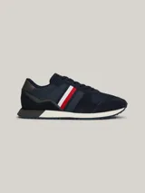 Zapatillas Tommy Hilfiger de estilo running, color azul marino con detalles en rojo, blanco y gris. Confeccionadas en poliéster con interior de poliéster, plantilla extraíble de goma termoplástica y poliuretano, y suela de goma dentada. Presentan cinta distintiva en el lateral, paneles con mezcla de texturas y parche con logo en la lengüeta.