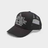 Gorro tipo trucker negro con visera curva, paneles frontales rígidos y paneles traseros de malla. Presenta un estampado frontal con el logo de Amiri, un pegaso y texto en color blanco.