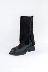 Bota negra de cuero con caña alta y detalle de cobertura de gamuza negra en la parte superior.